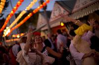 Women wearing Sevillana dresses dance during the traditional Feria de Abril (April fair) in the Andalusian capital of Seville
